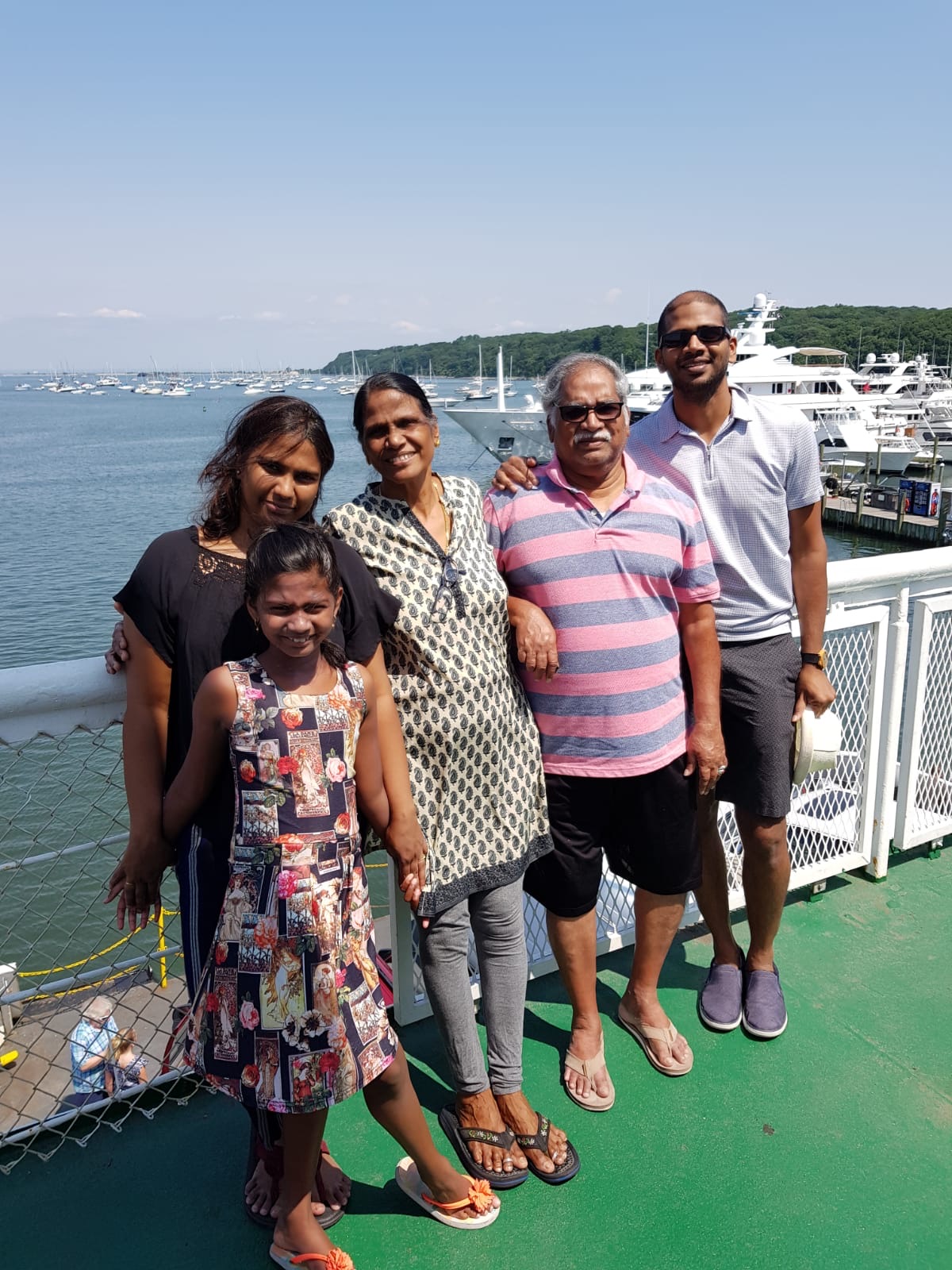 Family together on a ferry deck overlooking the harbor